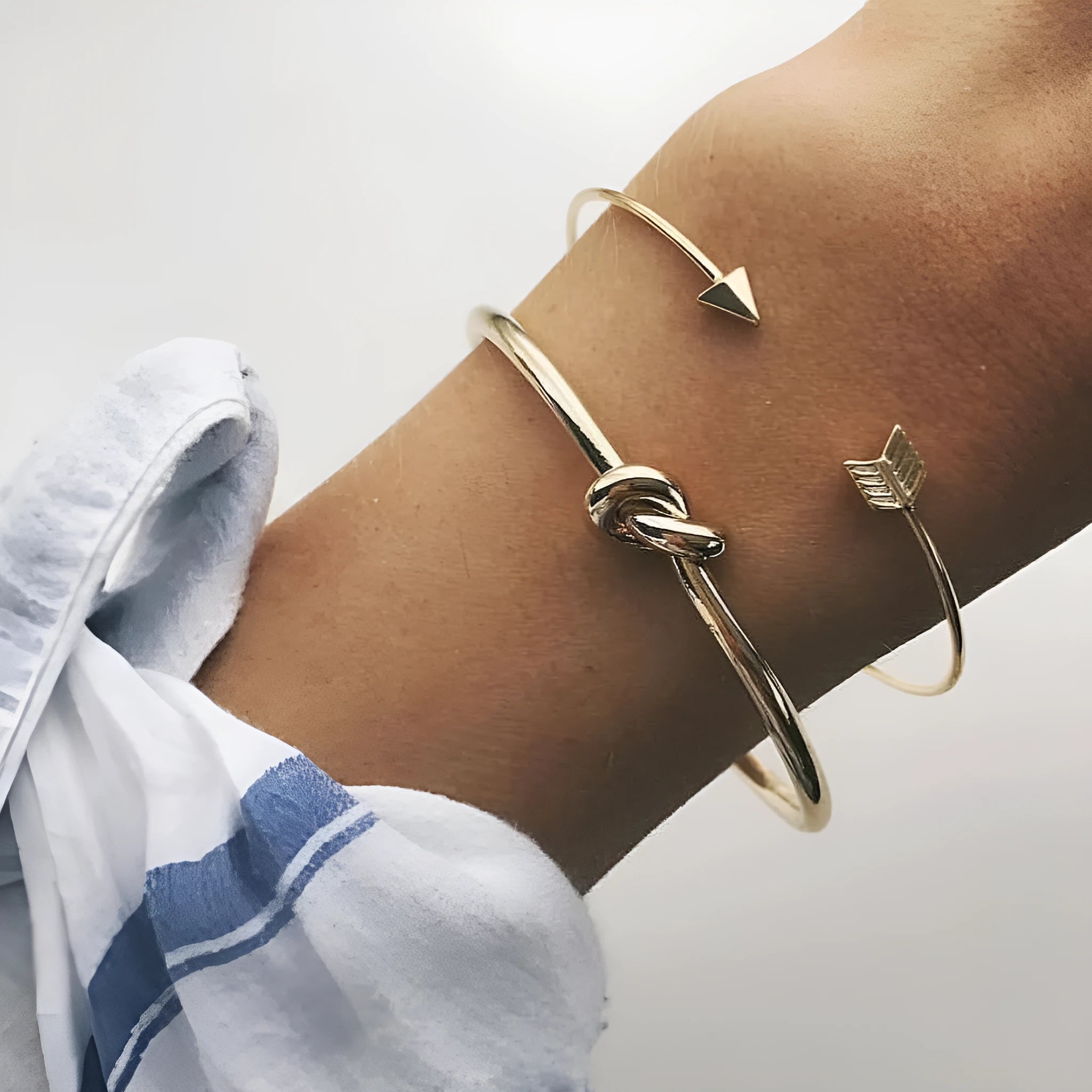 Gold women's vintage cuff bracelet with arrow knotted design on wrist