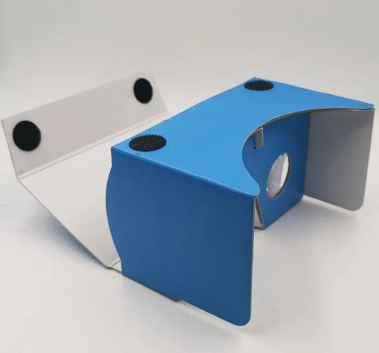Pink and white cardboard VR glasses for smartphones, shown with 3D lenses and a rubber headband.