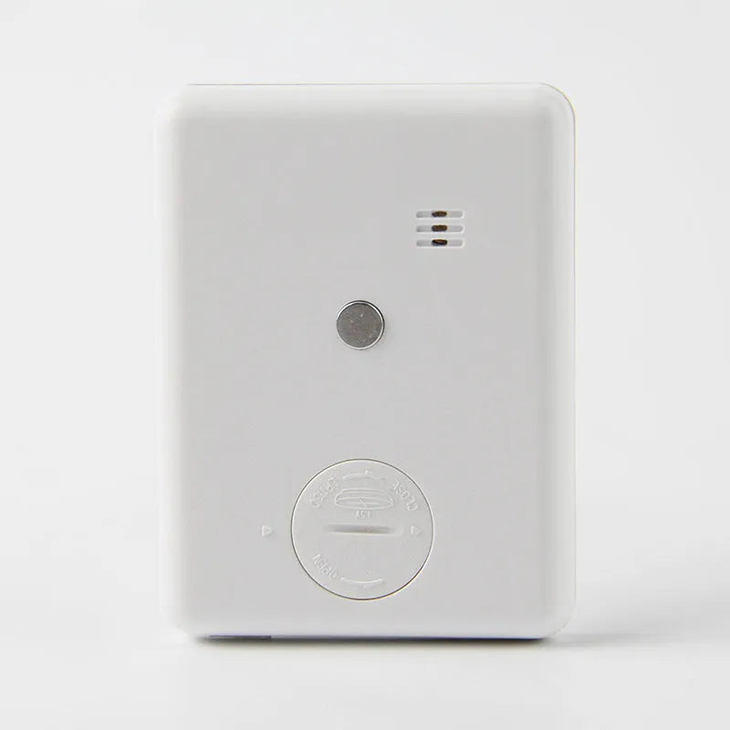 Black and white magnetic kitchen timer with countdown and count-up display on a refrigerator.