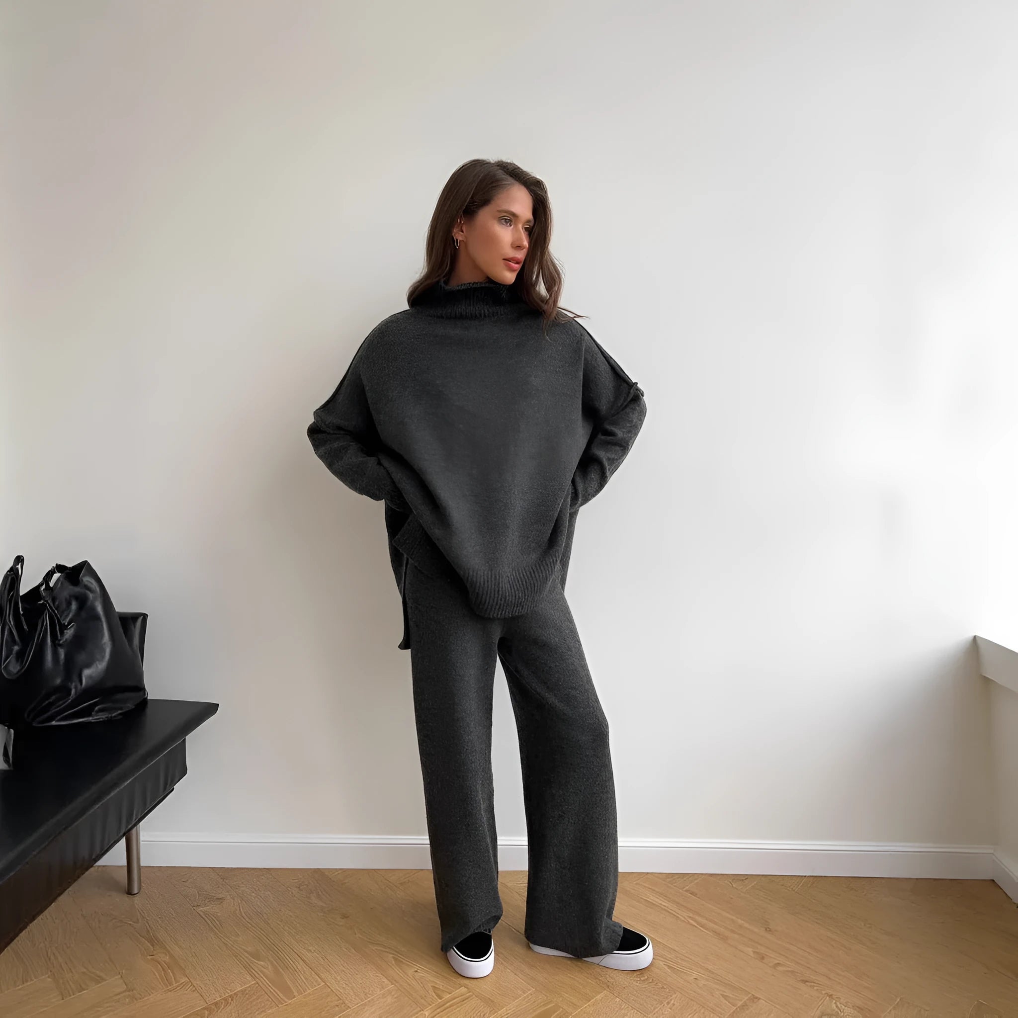 Women's knitted acrylic suit set with side-slit top and matching trousers in a solid colour.