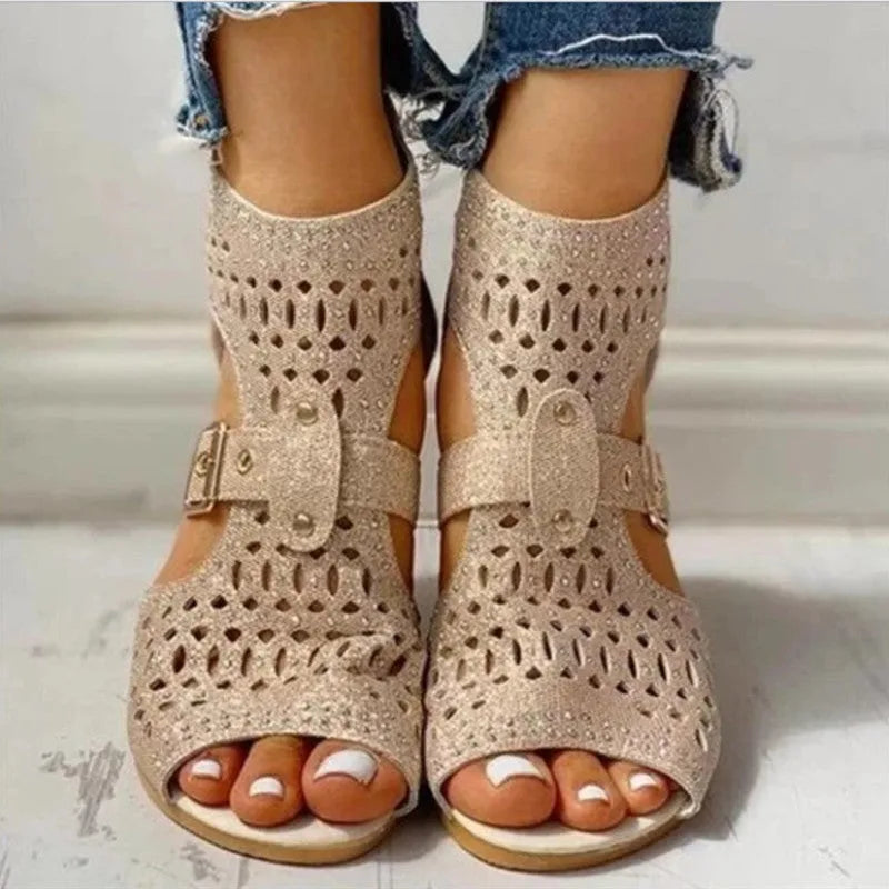 Women's beige rivet sandals with a back zipper and a low wedge heel.