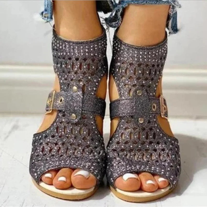 Women's beige rivet sandals with a back zipper and a low wedge heel.