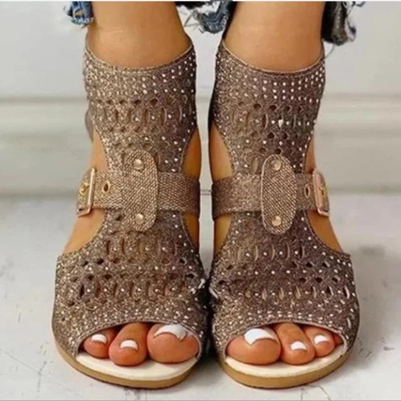 Women's beige rivet sandals with a back zipper and a low wedge heel.