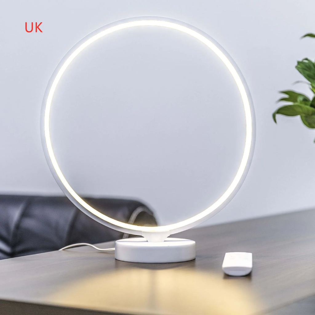 White Full Moon Lamp table light with remote control on a wooden surface.