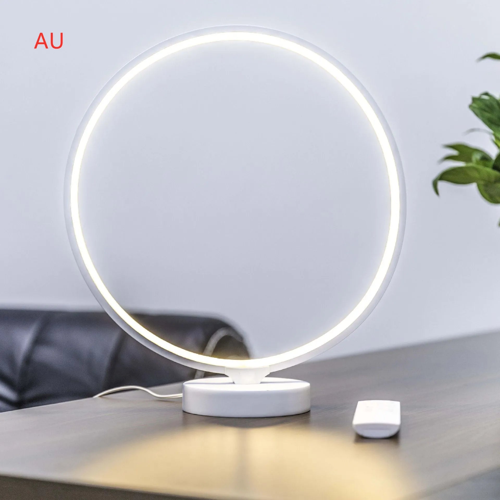 White Full Moon Lamp table light with remote control on a wooden surface.