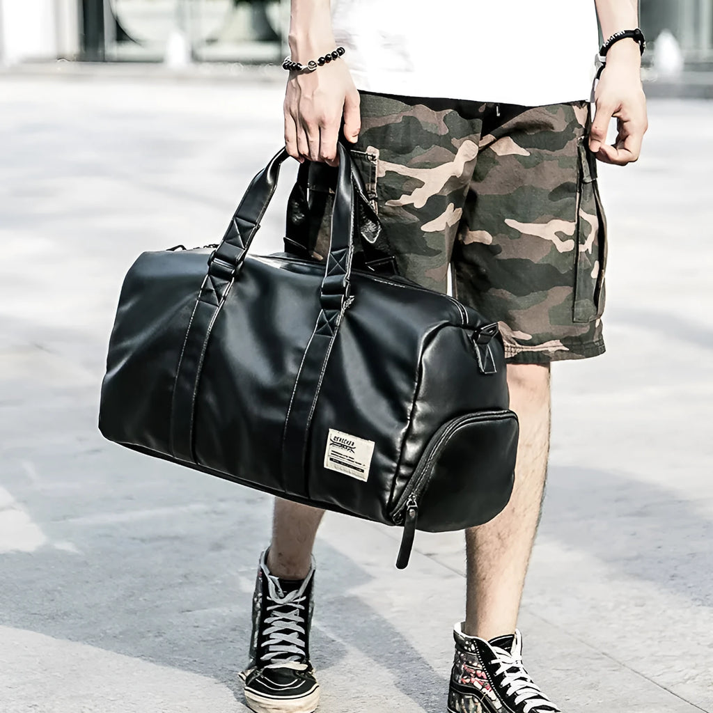 Black waterproof PU leather sports training bag showing internal laptop and camera pockets