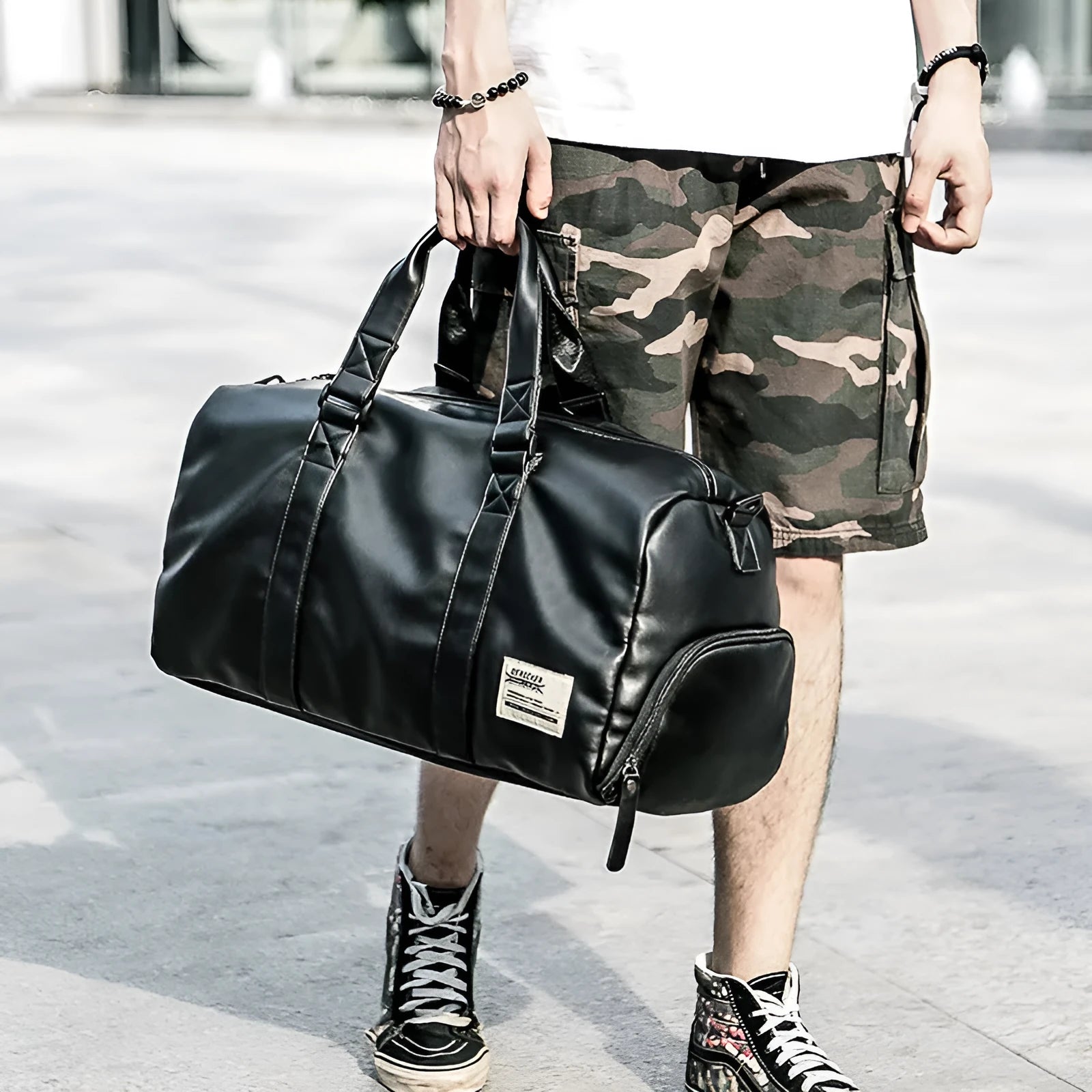 Black waterproof PU leather sports training bag showing internal laptop and camera pockets