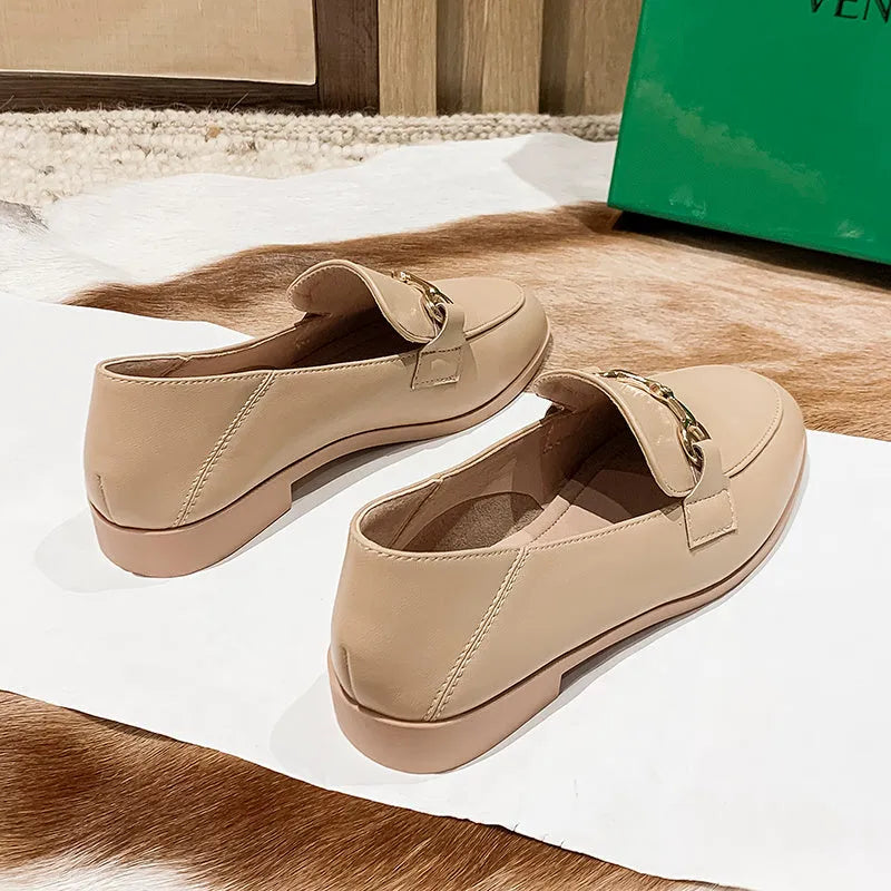 Women's black leather flat shoes with round toe, low heel 1-3cm, and rubber sole on white background