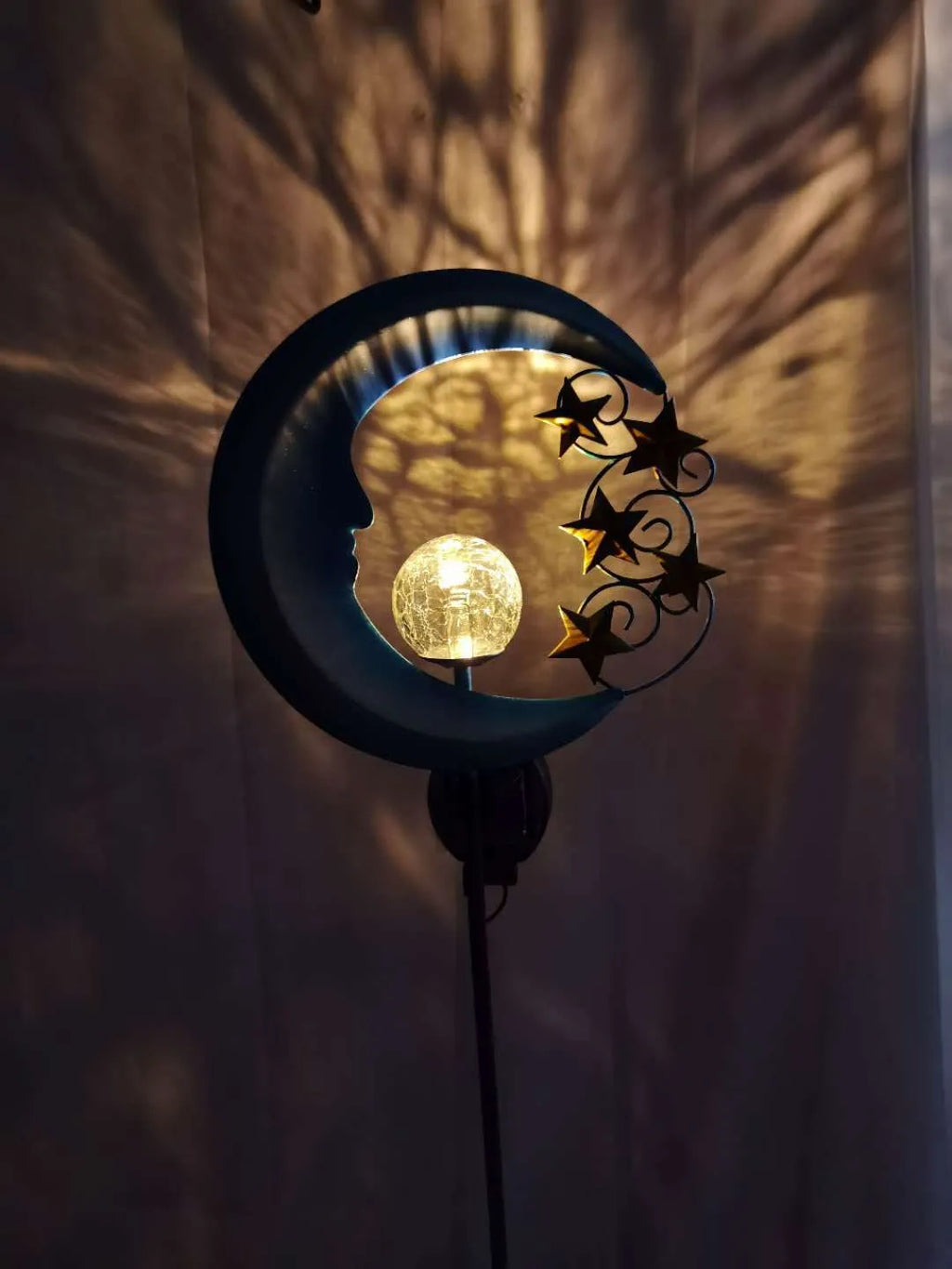 Solar hollow wrought iron blue moon LED lawn light with crack glass ball on grass