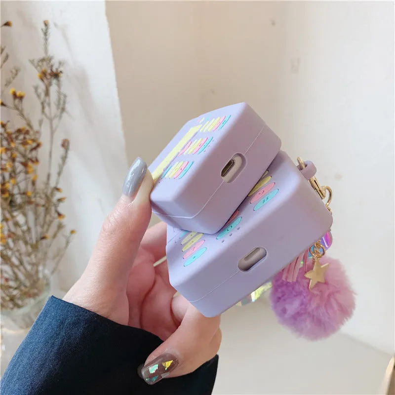 Purple silicone AirPods protective case with fluffy fur ball pendant attached