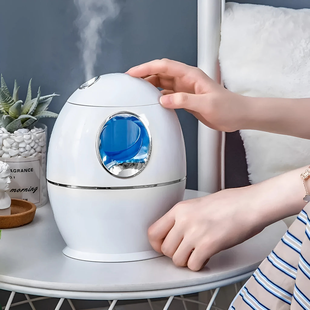 White round aromatherapy humidifier with USB cable and water tank showing mist output