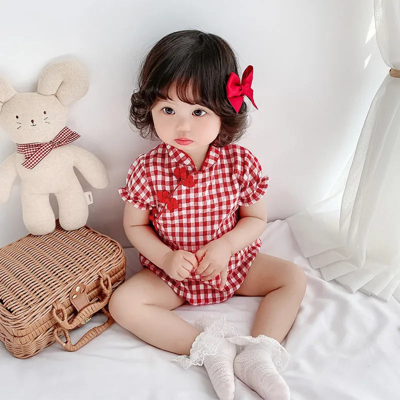 Red cotton baby cheongsam jumpsuit with short sleeves and triangle climbing design on white background