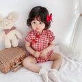 Red cotton baby cheongsam jumpsuit with short sleeves and triangle climbing design on white background