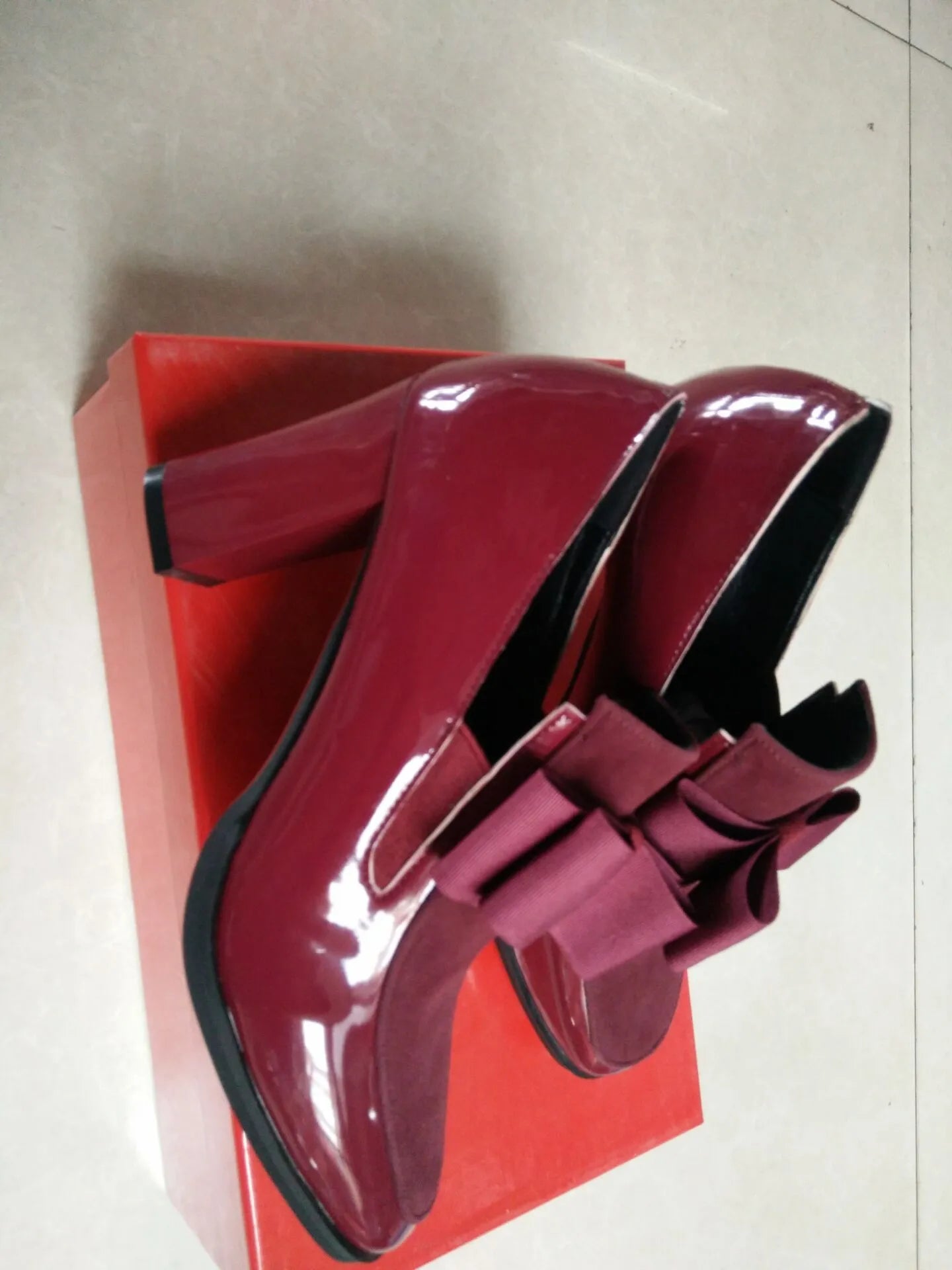 Black patent leather women's high heels with a thick chunky heel and square toe on a rubber sole.