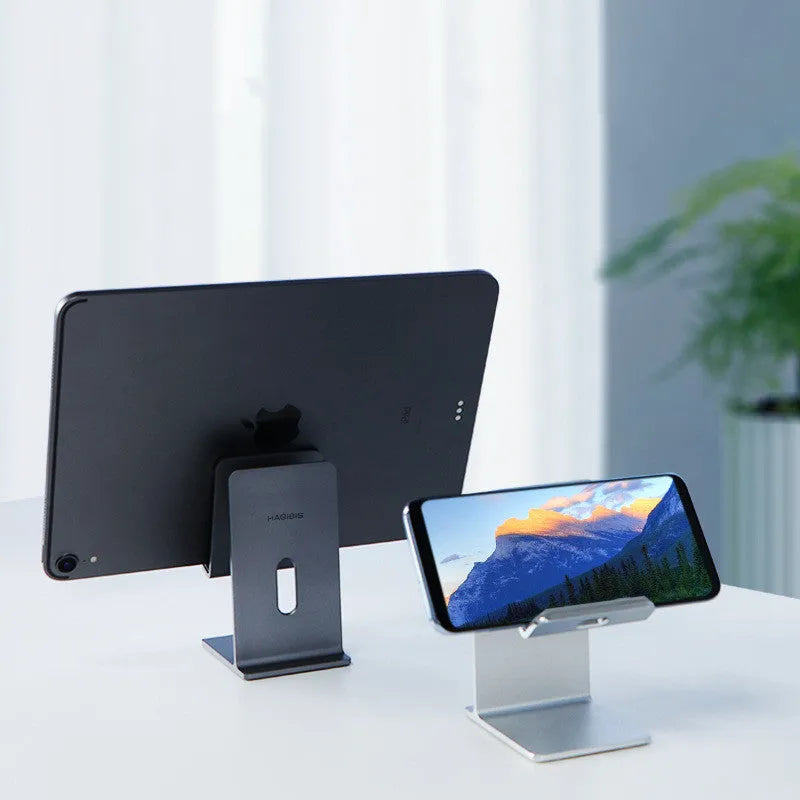 Alloy mobile phone and tablet holder in dark gray on a wooden desk