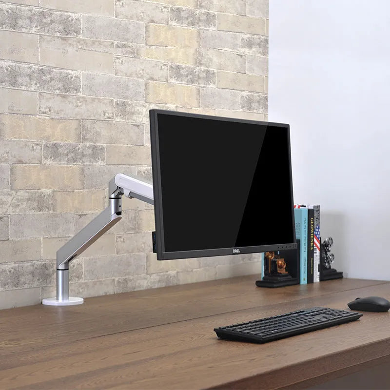 Lifting computer stand in dark grey with a monitor placed on top, shown on a desk for ergonomic viewing height.
