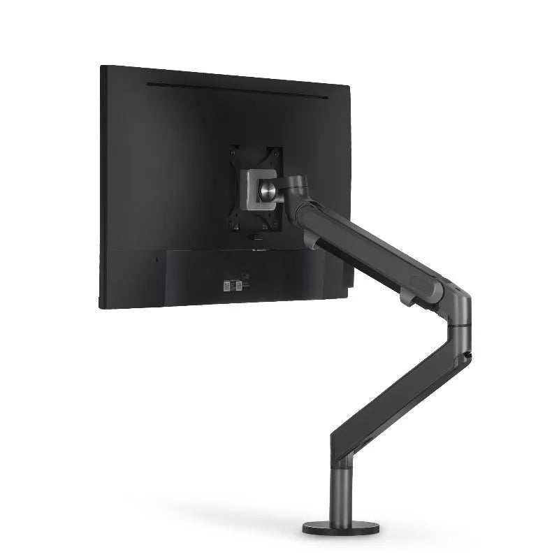 Lifting computer stand in dark grey with a monitor placed on top, shown on a desk for ergonomic viewing height.