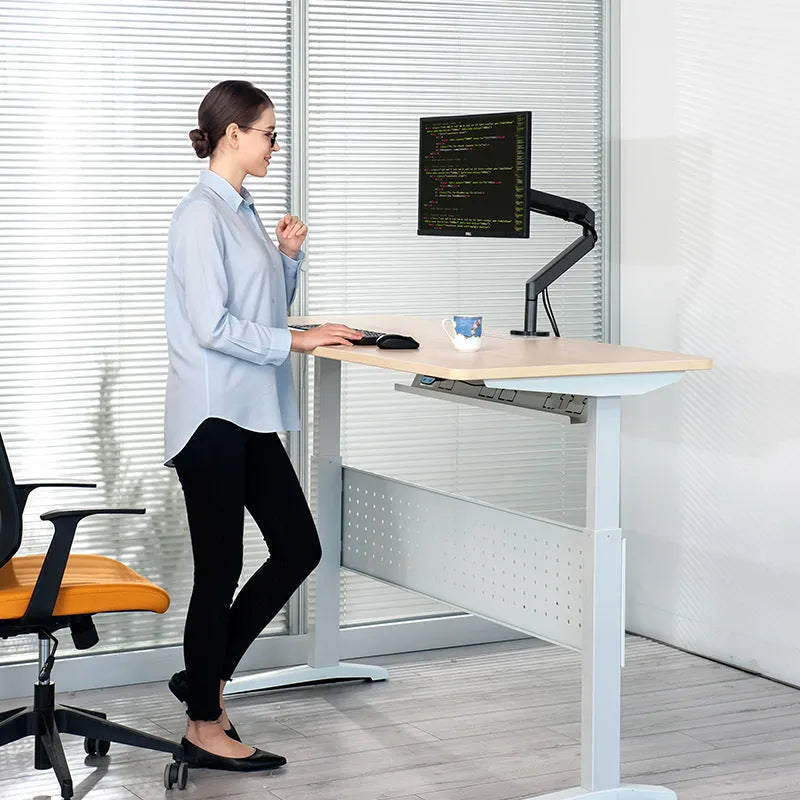 Lifting computer stand in dark grey with a monitor placed on top, shown on a desk for ergonomic viewing height.