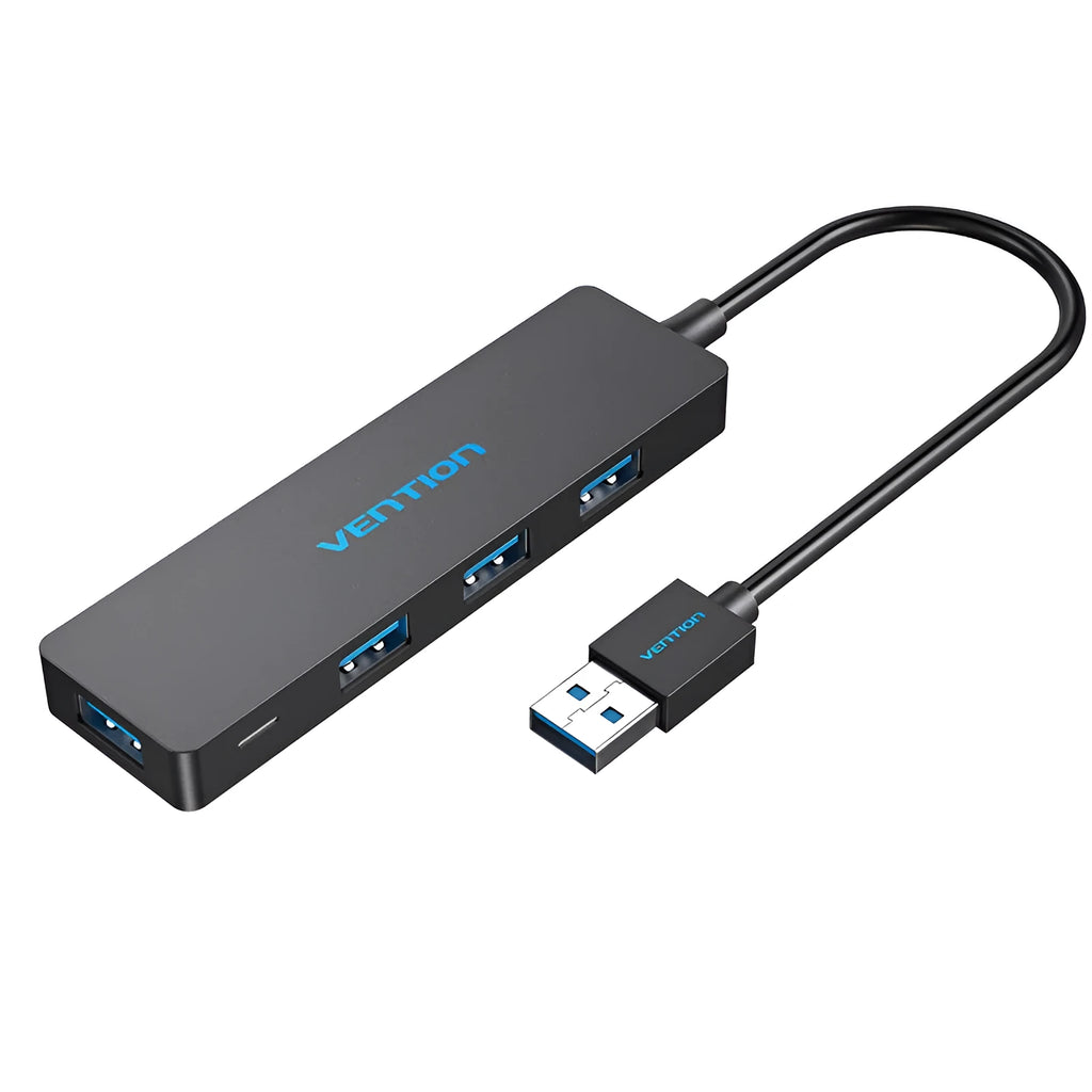 Black four-port USB 3.0 hub with a short cable next to a laptop