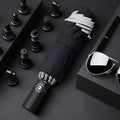 Black automatic reverse umbrella shown open, showcasing its 10-bone frame and folded compact size.