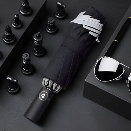 Black automatic reverse umbrella shown open, showcasing its 10-bone frame and folded compact size.