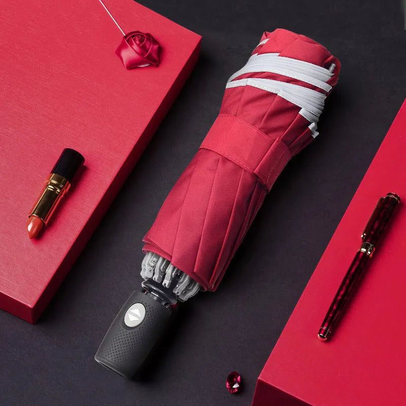 Black automatic reverse umbrella shown open, showcasing its 10-bone frame and folded compact size.