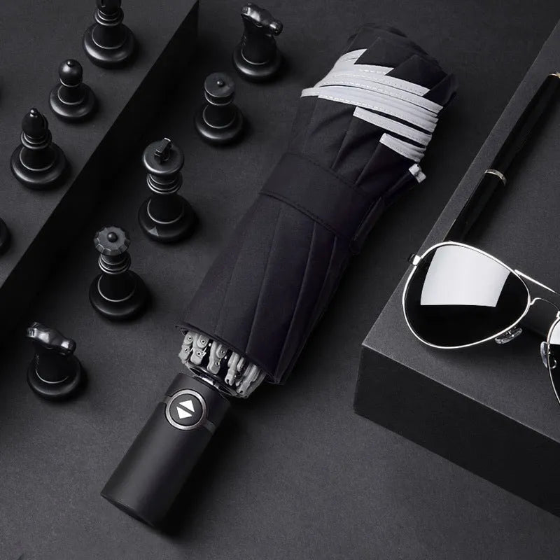 Black automatic reverse umbrella shown open, showcasing its 10-bone frame and folded compact size.