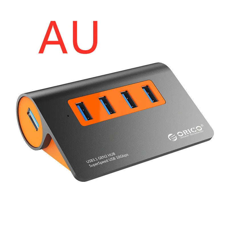 Dark grey USB hub with four ports and orange accents, showing aluminium construction and separate data cable