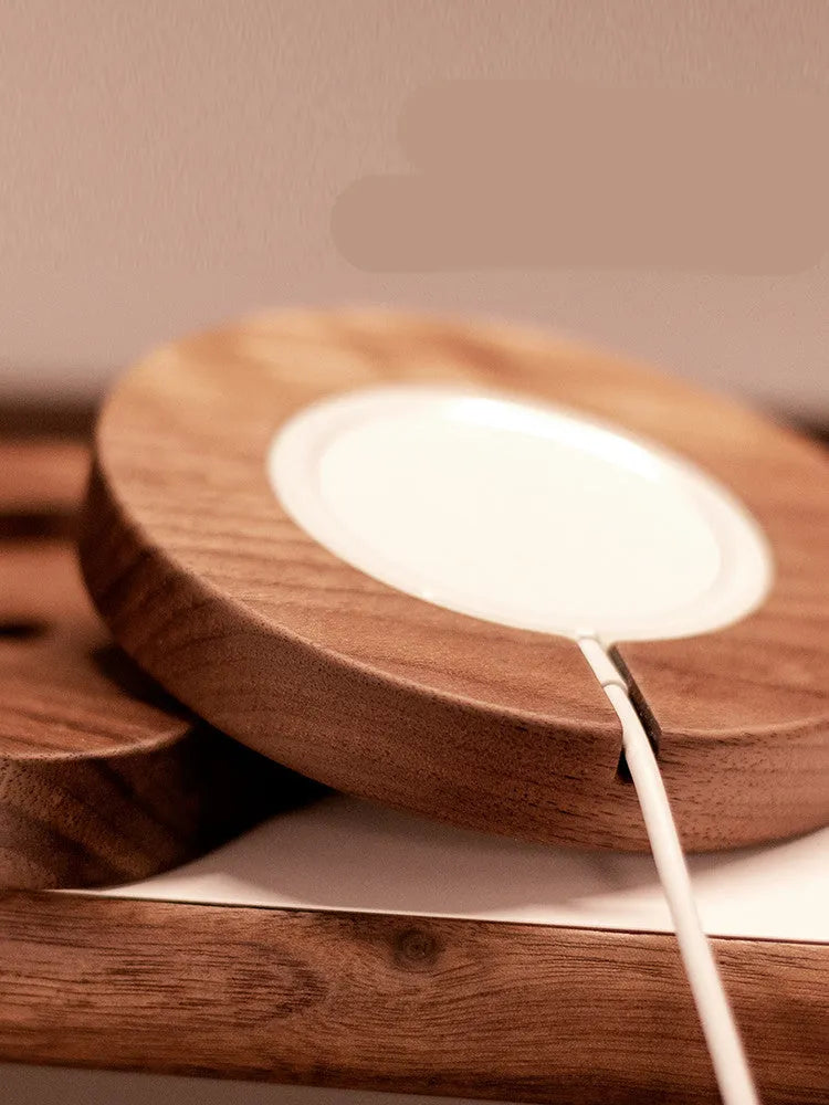 Walnut wood magnetic wireless charger bracket on desk with smartphone