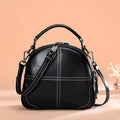 Round leather handbag with zippered closure and double soft handles in wine red colour