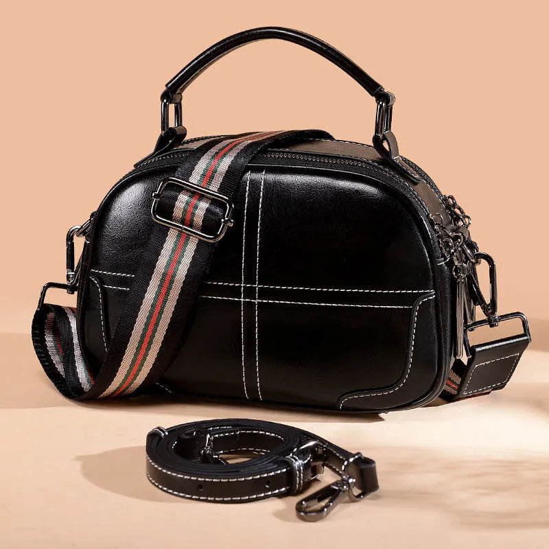 Round leather handbag with zippered closure and double soft handles in wine red colour