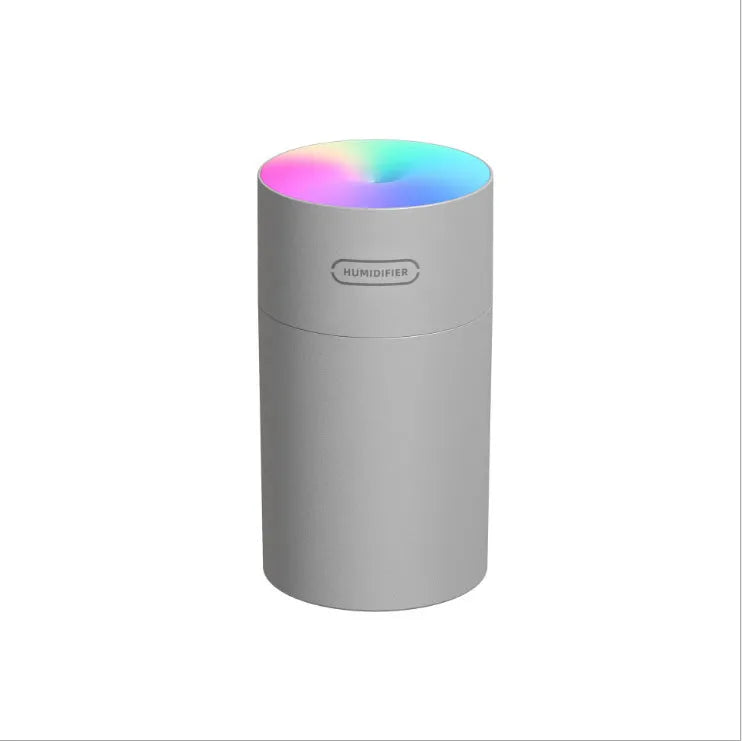 Pink USB desktop humidifier with colourful LED lights and 300ml water tank on wooden desk