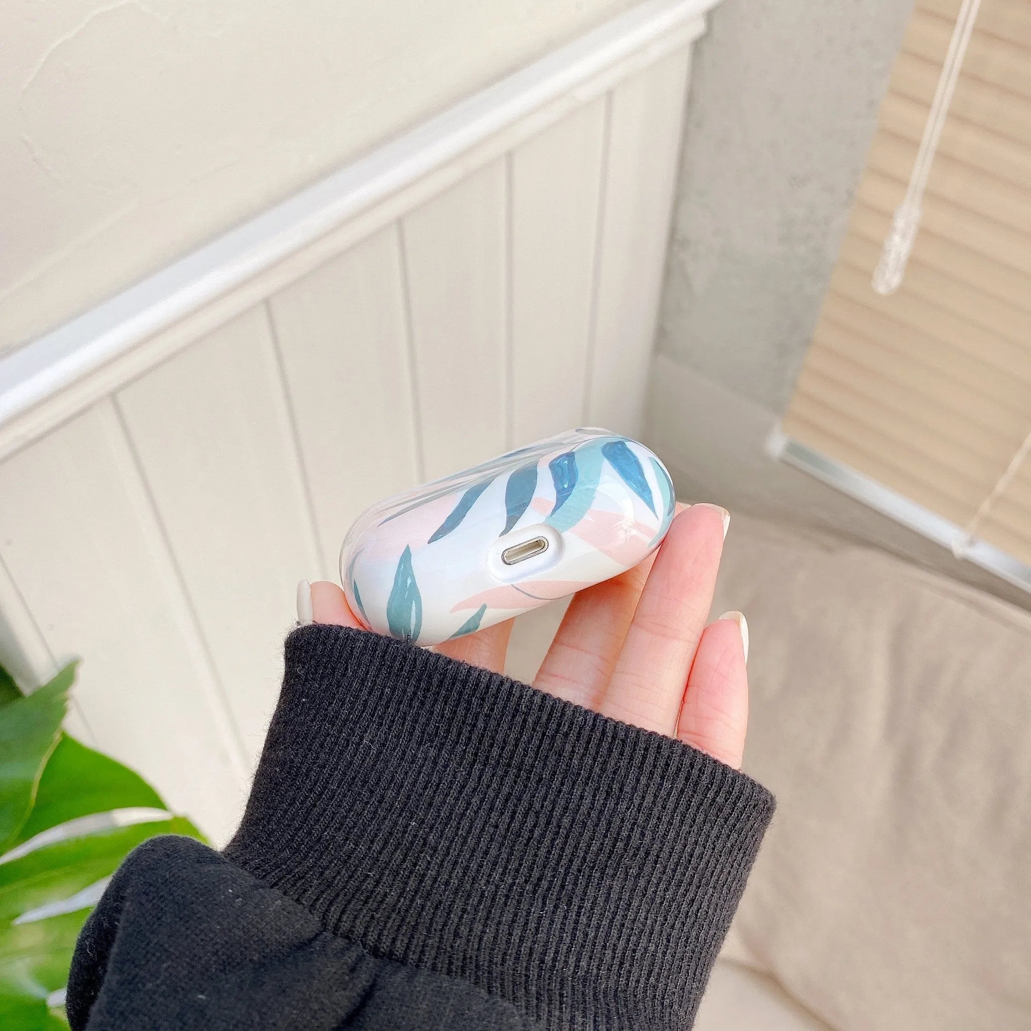 Blue and green soft TPU AirPods cases featuring a painted tropical banana leaves pattern.