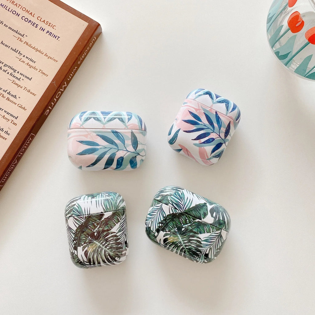 Blue and green soft TPU AirPods cases featuring a painted tropical banana leaves pattern.