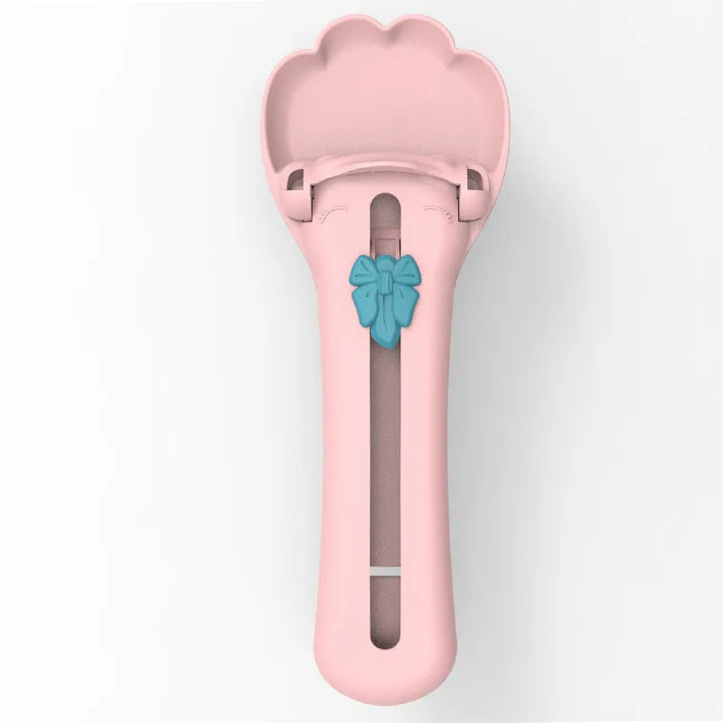 Green and pink pet feed spoon and snack squeezer tool for cat and dog food.