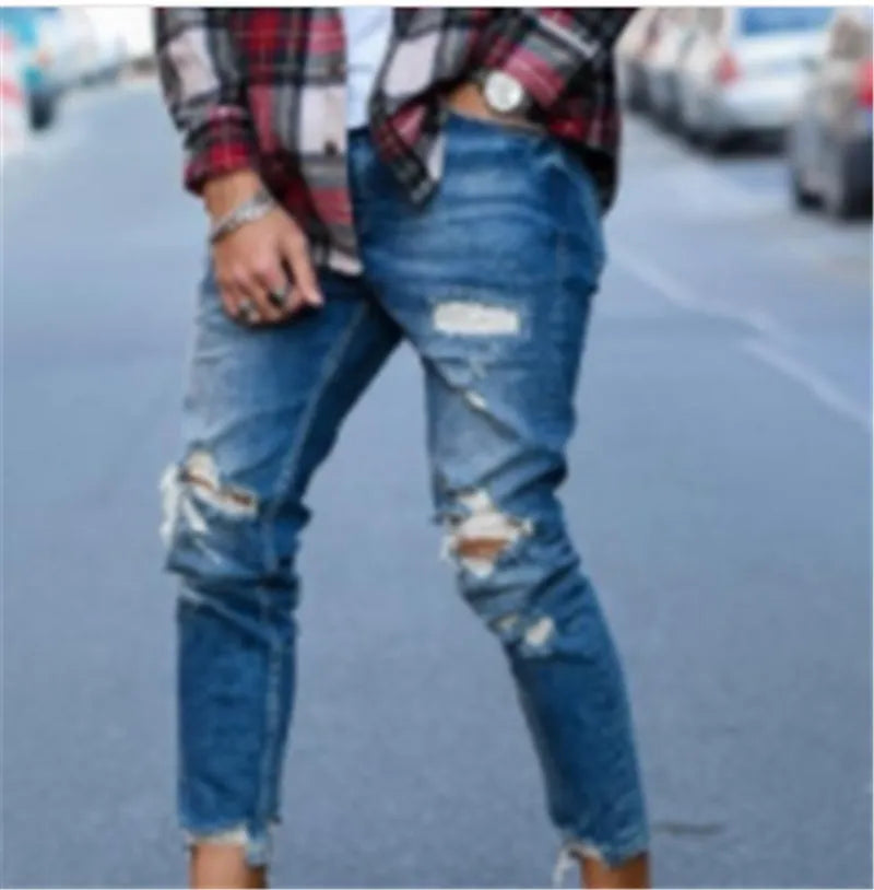 Men's blue jeans with hole detailing showing cotton fabric texture and distressed design