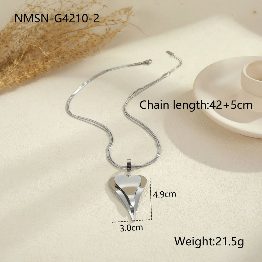 Close-up of a women's stainless steel necklace with a double heart snake bones chain and a geometric pendant.