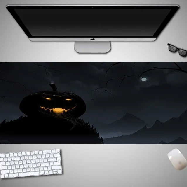 Oversized Halloween graphic cloth mouse pad on a desk, showing non-slip rubber base.