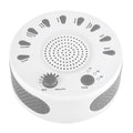 White portable white noise sleep sound machine with control knob on a bedside table.