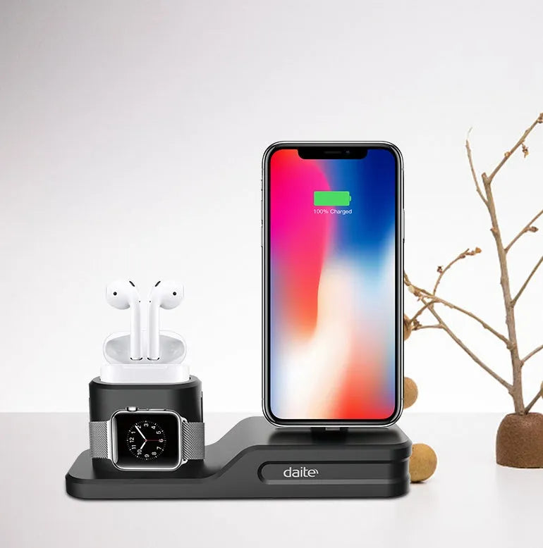 Black silicone 3-in-1 charging base for iPhone, iWatch, and AirPods on a plain surface