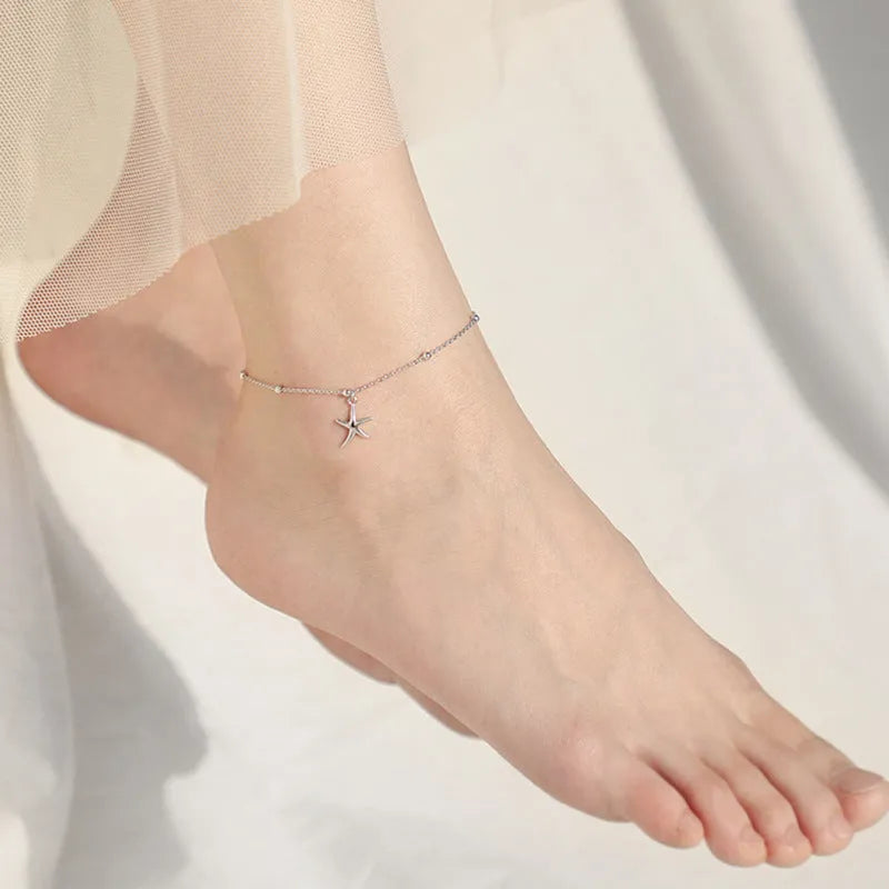 Silver starfish charm anklet on ankle showing S925 sterling silver construction and lobster clasp