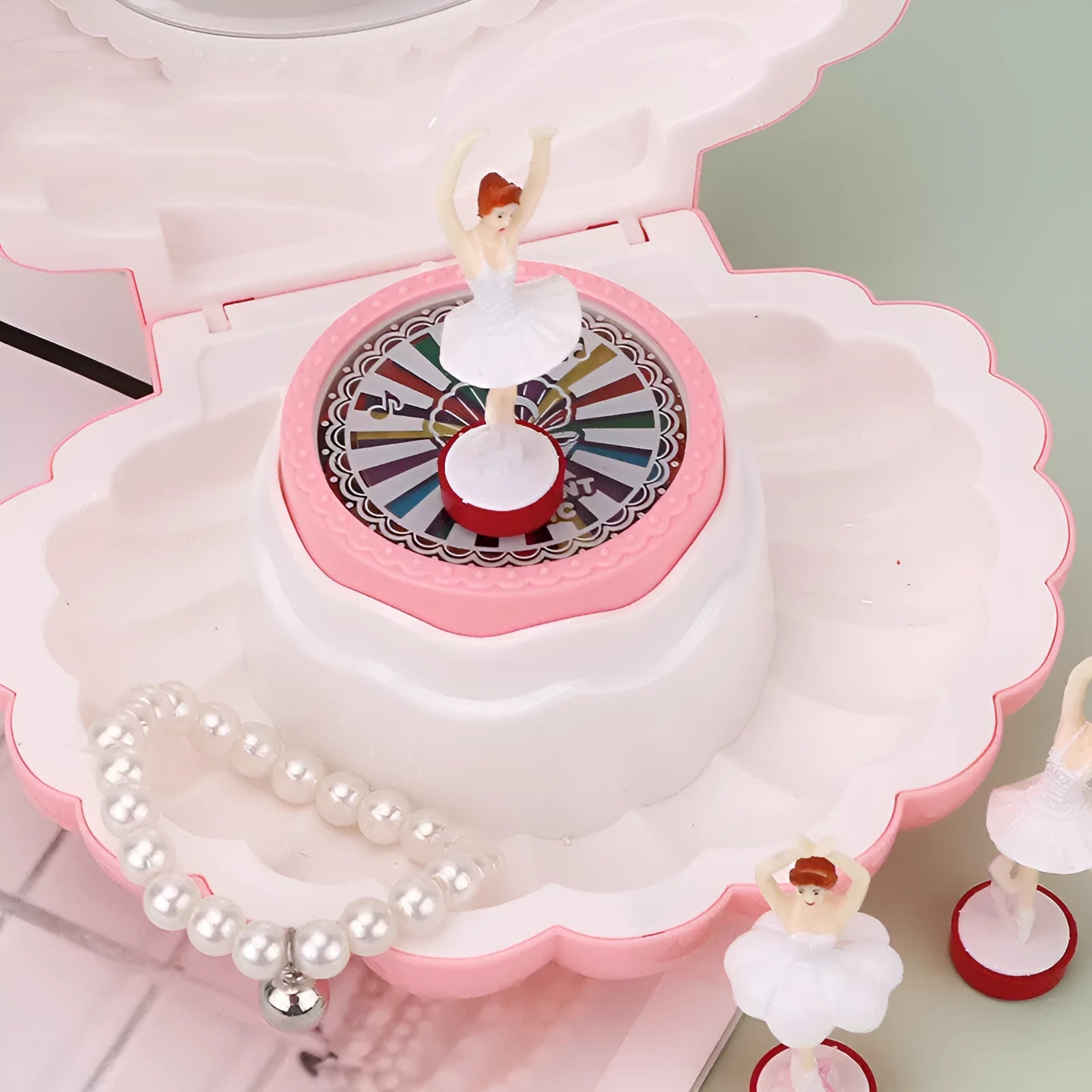 Plastic ballet girl music box in random colour, shows figure above shell, 160x130x155mm