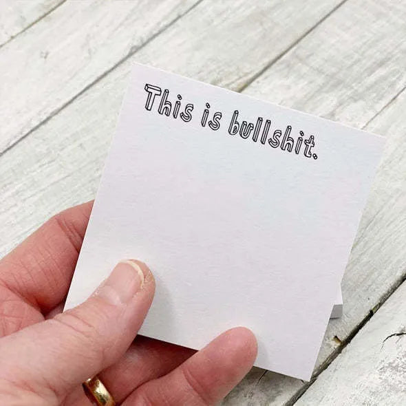 75mm square paper sticky note pad with funny English text cover designs on a desk.