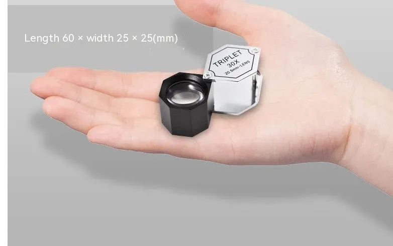 Handheld portable magnifying glass for jewellery and coin inspection with metal frame.