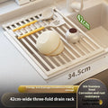 Milky white foldable stainless steel kitchen draining rack shown in a sink.