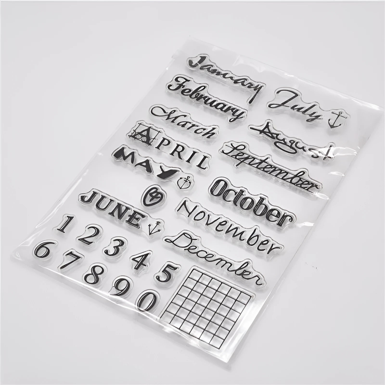 Close-up of a transparent silicone craft stamp featuring vintage-style calendar icons on a digital table background.