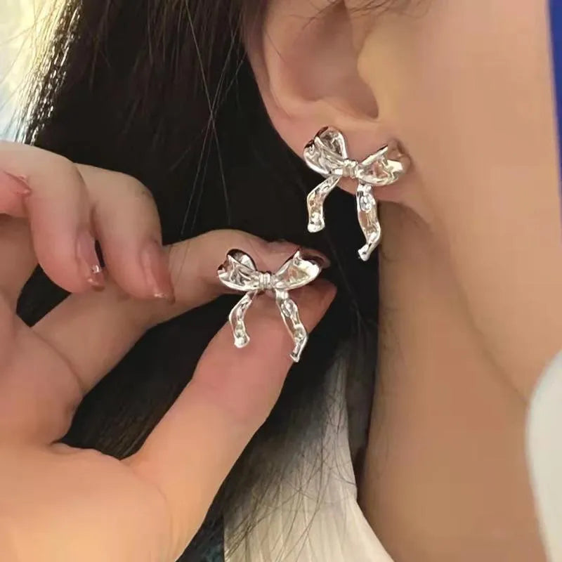 Gold bow earrings simple style alloy electroplated finish pair on white background