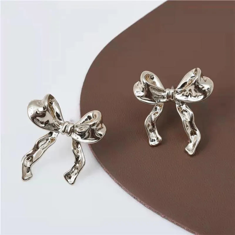 Gold bow earrings simple style alloy electroplated finish pair on white background