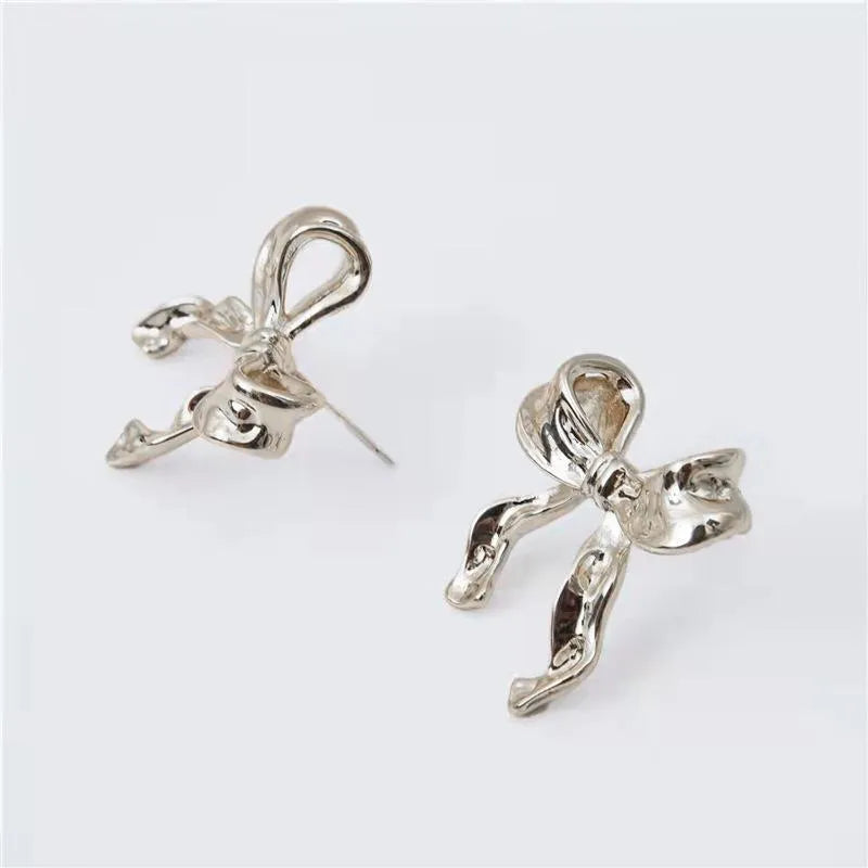 Gold bow earrings simple style alloy electroplated finish pair on white background