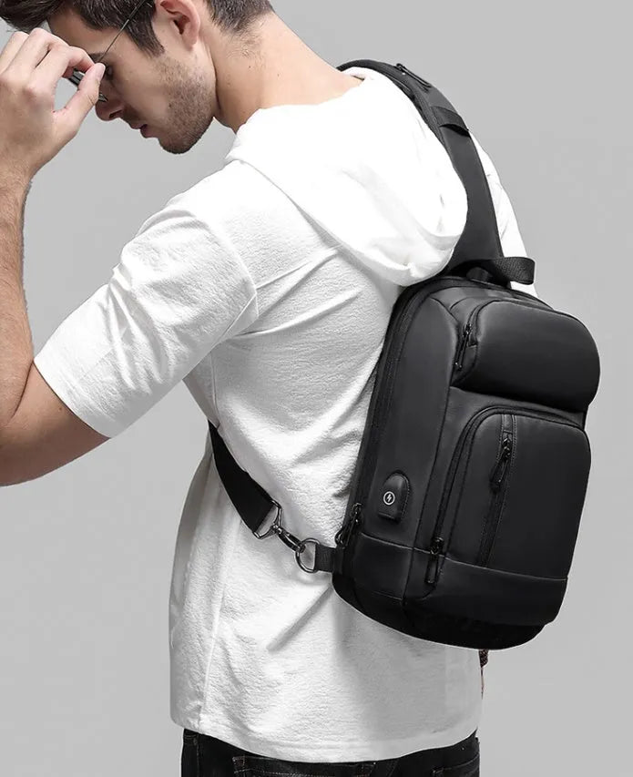 Black medium-sized PVC outdoor shoulder bag with a single strap and internal organiser pockets.